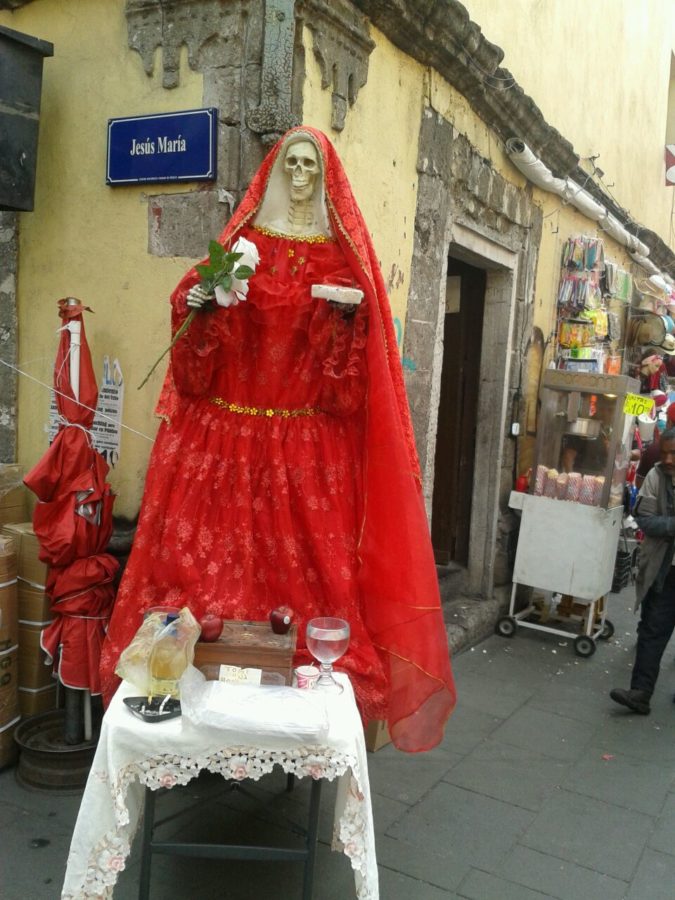 Altar to the Santa Muerte with different offerings: cigarettes, fruit, and water. Mexico City. Photo: Jessie Marroquín.