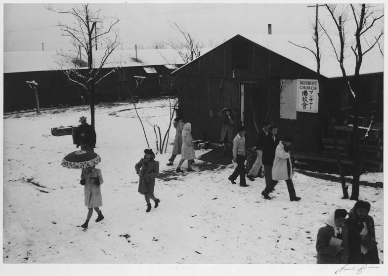 People leaving Buddhist church, winter II, Manzanar Relocation Center, California, 1943. Photograph by Ansel Adams. 