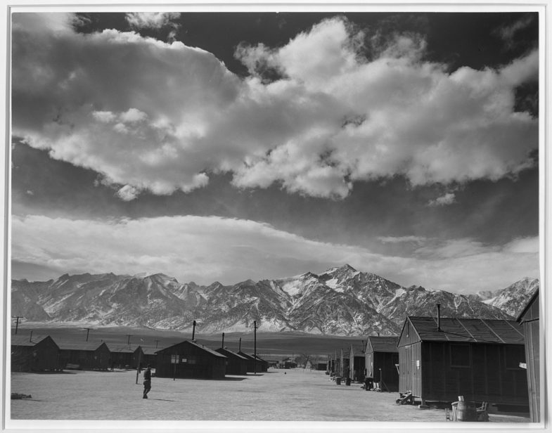 Manzanar street scene, clouds, Manzanar Relocation Center, California, 1943. Photograph by Ansel Adams. 