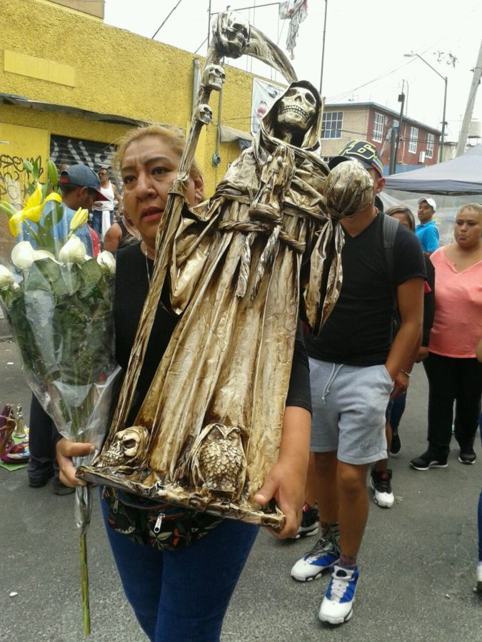 Devotee of the Santa Muerte, Alfarería Street, Tepito, Mexico City, April 1, 2019. The Santa Muerte has her usual scythe and world in both hands. Photo: Jessie Marroquín.