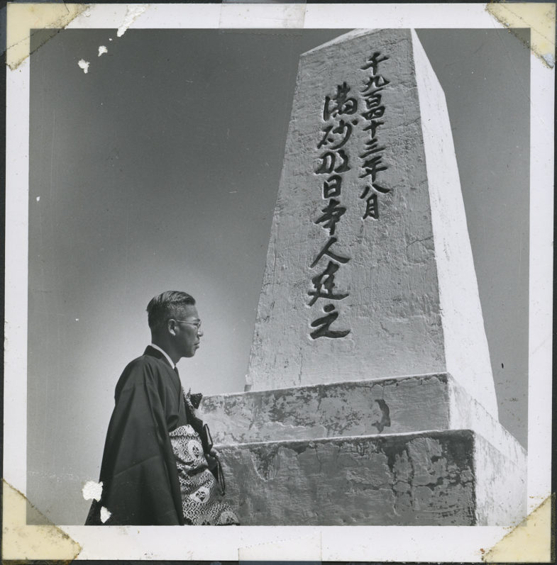 Rev. Shinjo Nagatomi standing in front of the Manzanar cemetery monument. Courtesy: Manzanar National Historic Site, Shinjo Nagatomi Collection. 