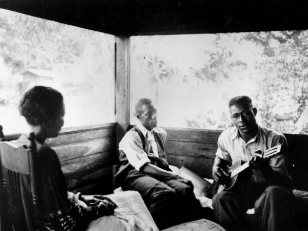 Gabriel Brown playing guitar as Rochelle French and Zora Neale Hurston listen- Eatonville, Florida (1935) via Florida Memory: State Library and Archives of Florida, Folk Life Collection